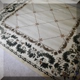 DR04. Beige rug with green vine border. 7'6” x 9'6”